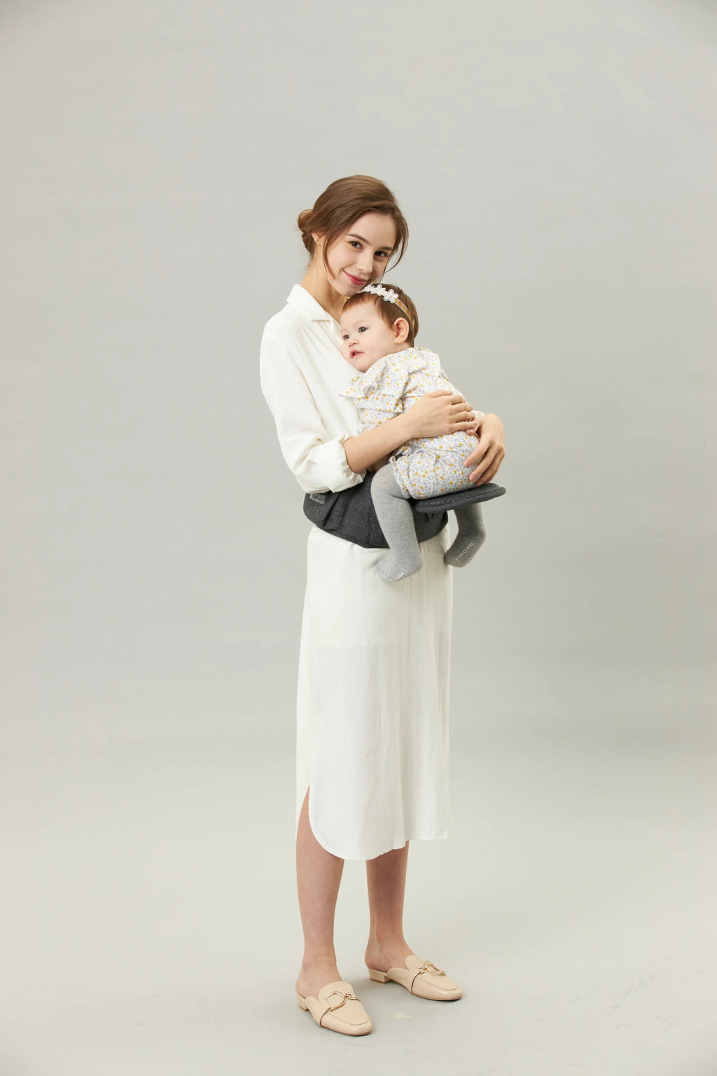 Mother holding baby in ergonomic hip seat carrier, bebefit.eu, Premium ergonomic baby carrier