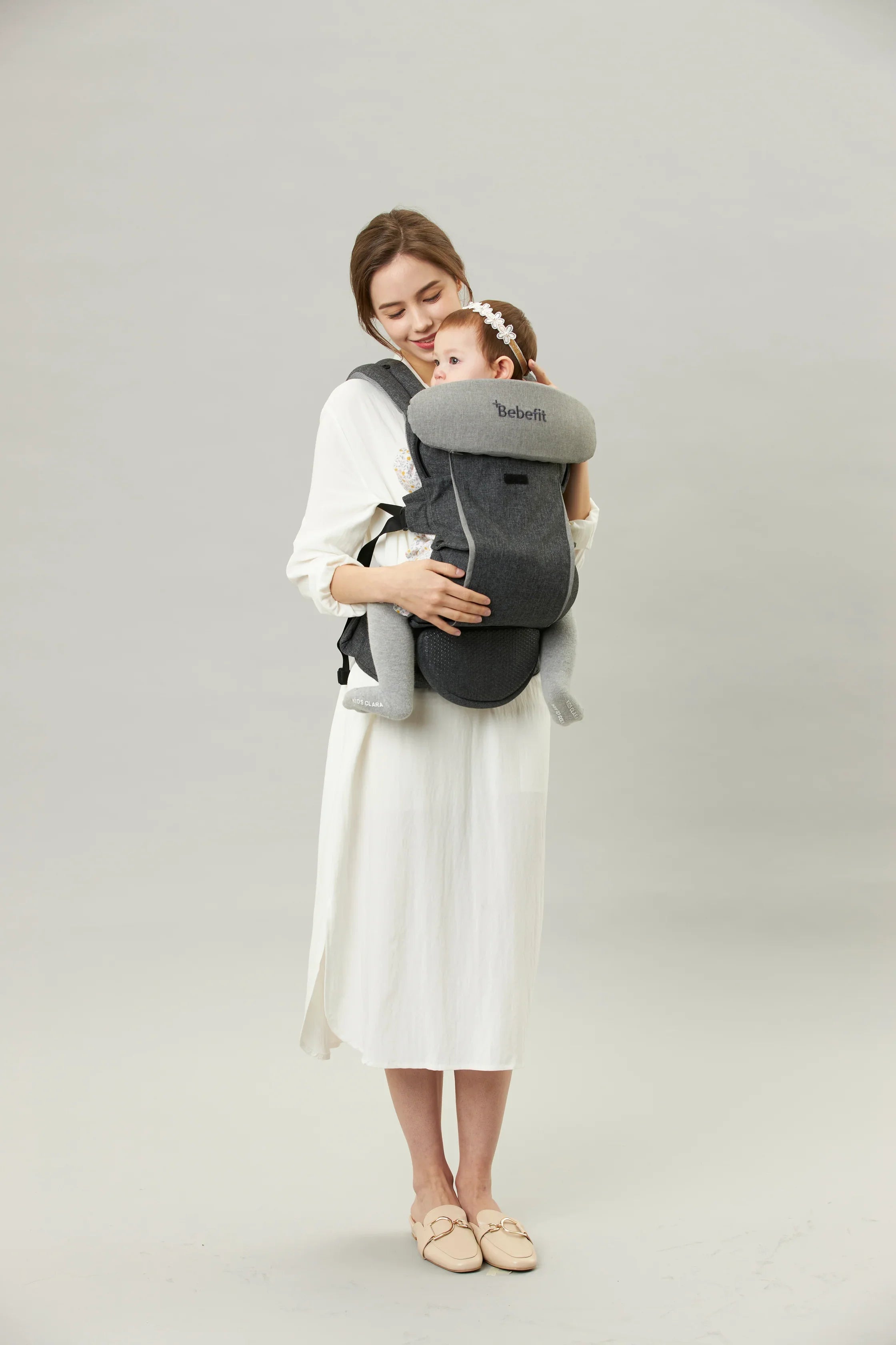 Mother carrying baby in ergonomic Bebefit baby carrier, gray, bebefit.eu