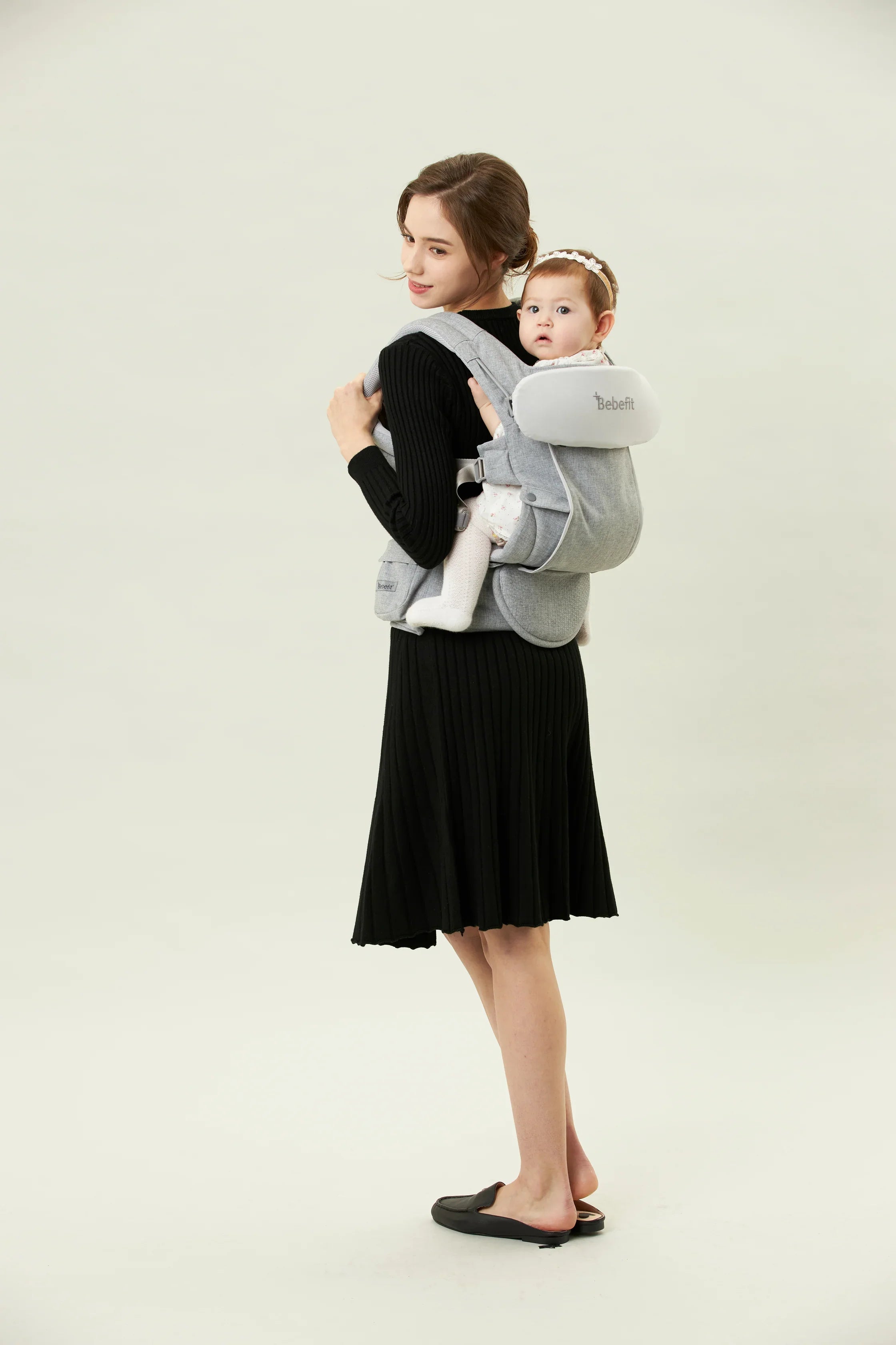 Woman carrying baby in ergonomic gray baby carrier, bebefit.eu, Bebefit Baby Carrier