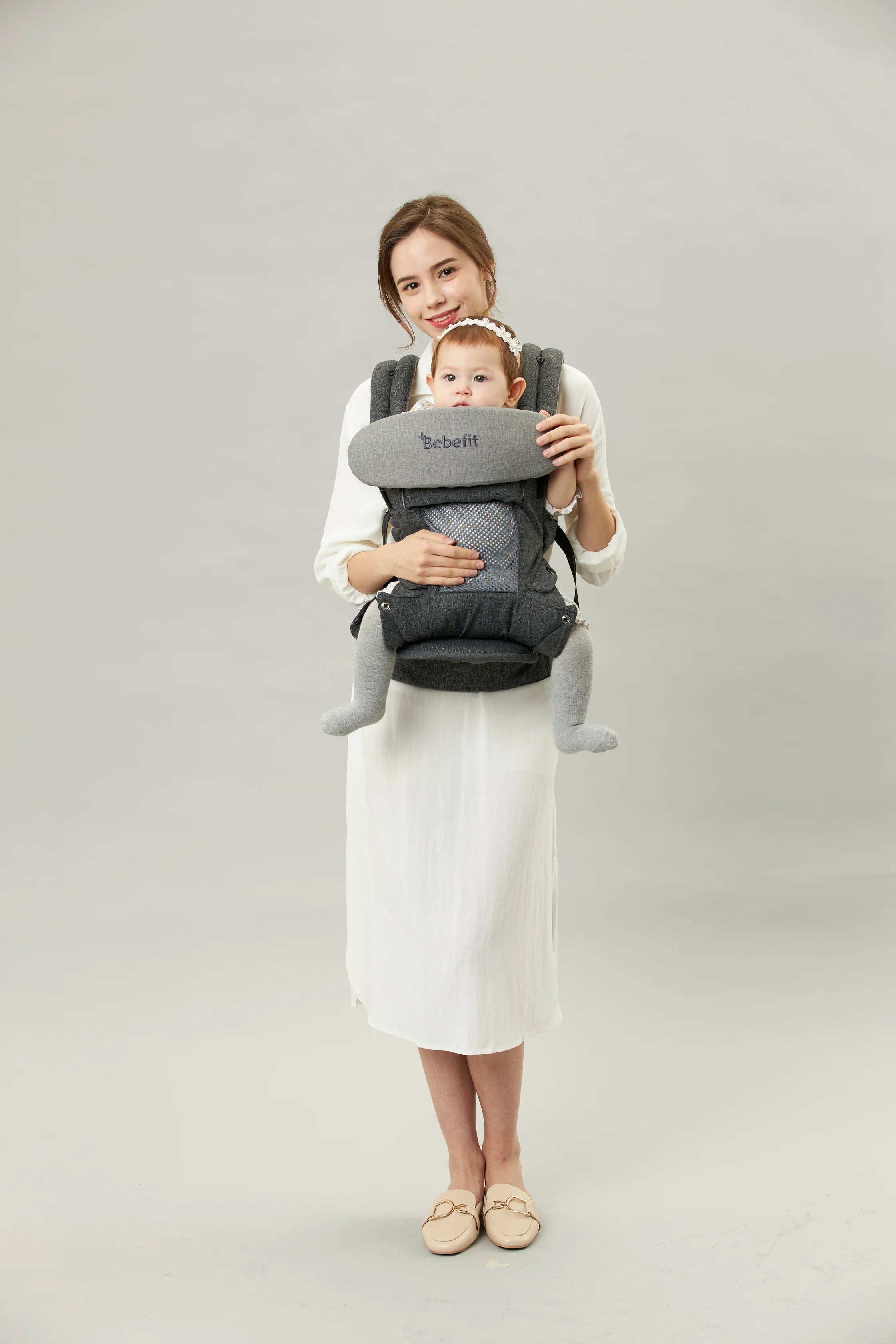 Mother carrying baby in grey ergonomic baby carrier Bebefit Hip Seat Carrier, bebefit.eu