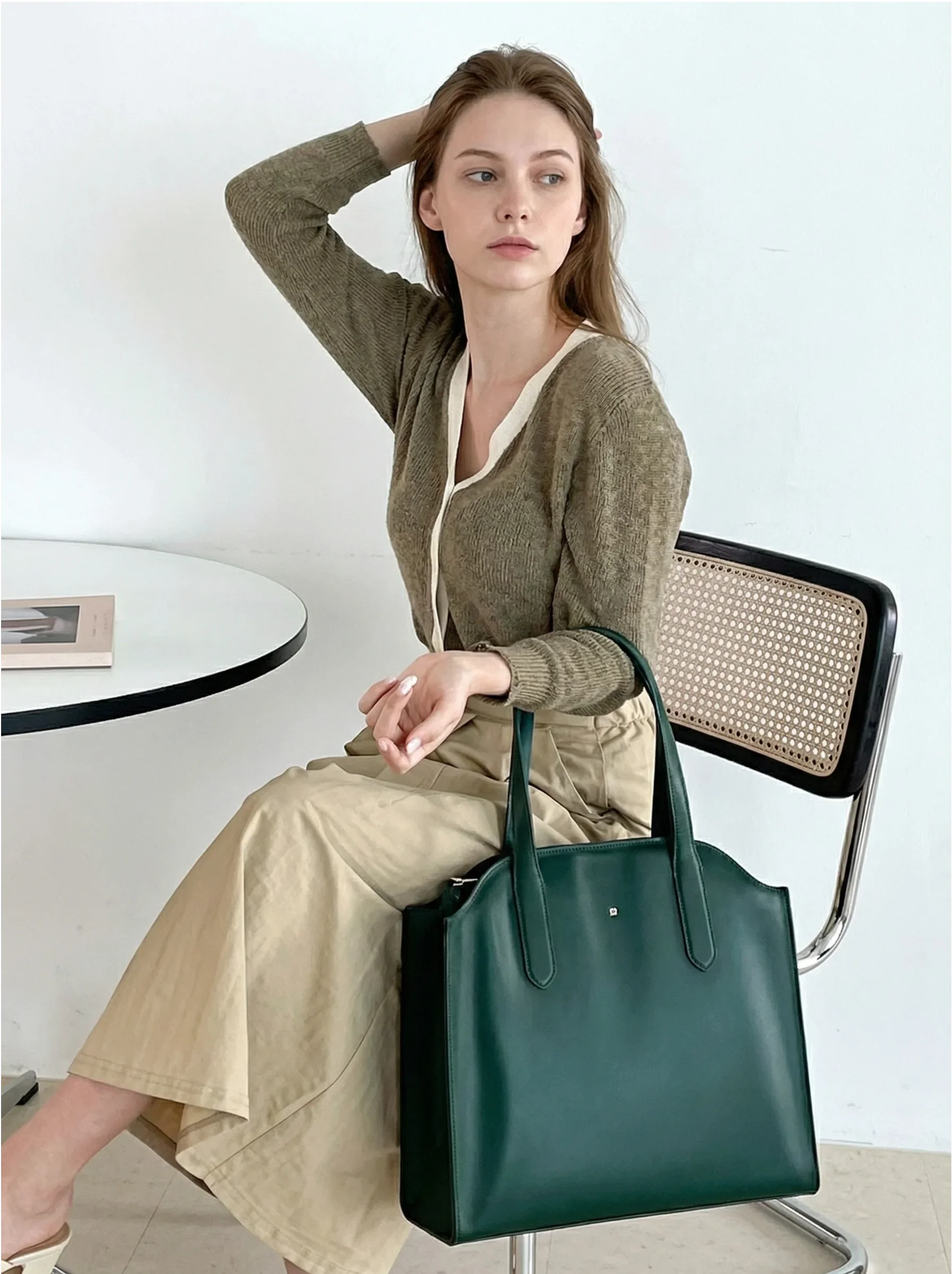 Woman seated with green tote bag, neutral outfit, product title, bebefit.eu