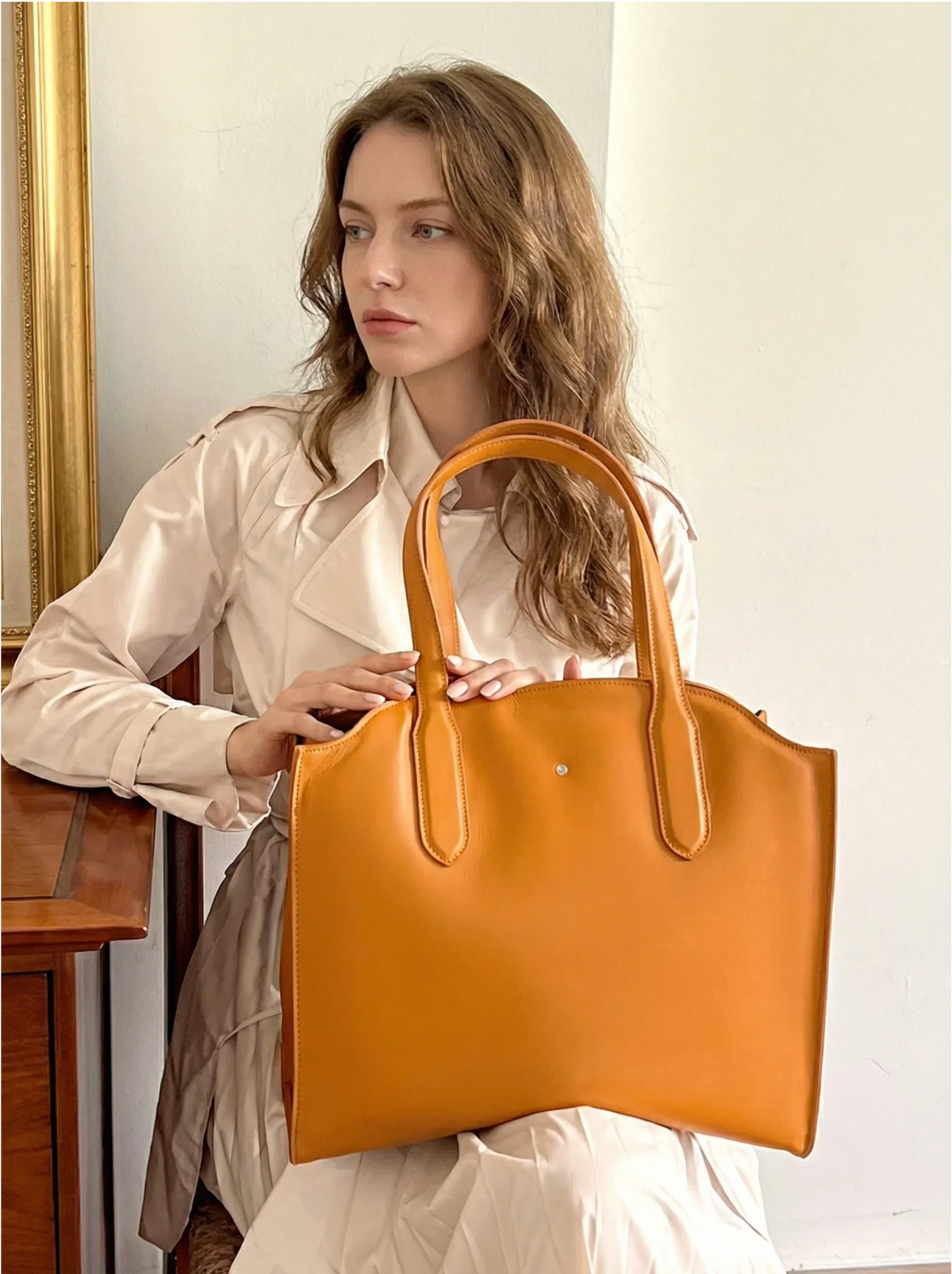 Woman in beige coat holding large tan tote bag, bebefit.eu, edited model 2