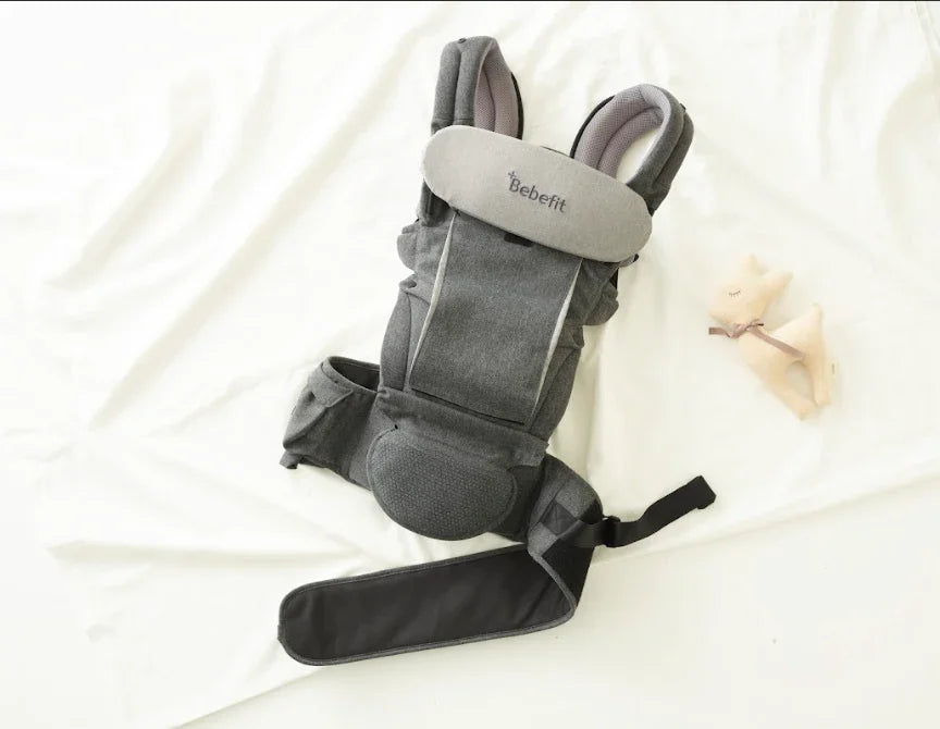 Bebefit ergonomic baby carrier in grey on white background with toy, bebefit.eu